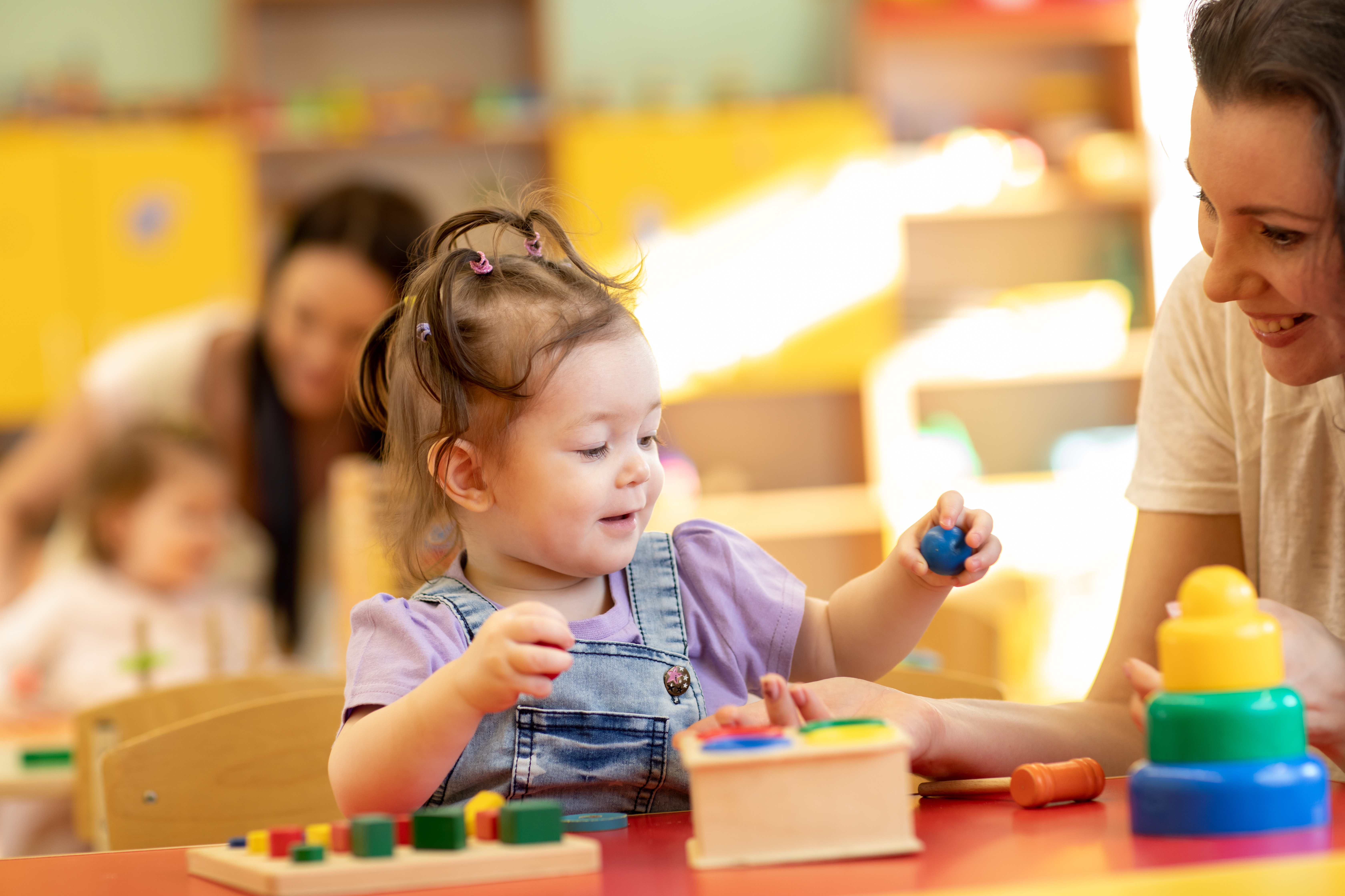 toddler-in-nursery-with-wooden-bead.jpeg